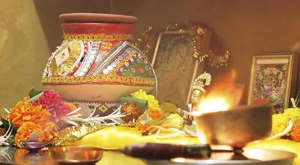 Decorated kalash with a ghee lamp and marigold flowers