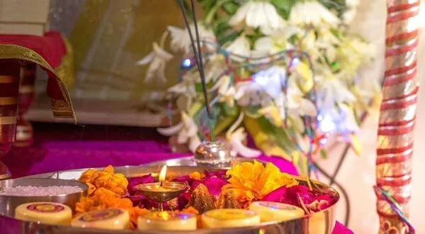 Puja thali with lit diyas and marigold flowers
